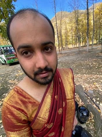 Adrit Mom in a saree surrounded by autumn foliage.